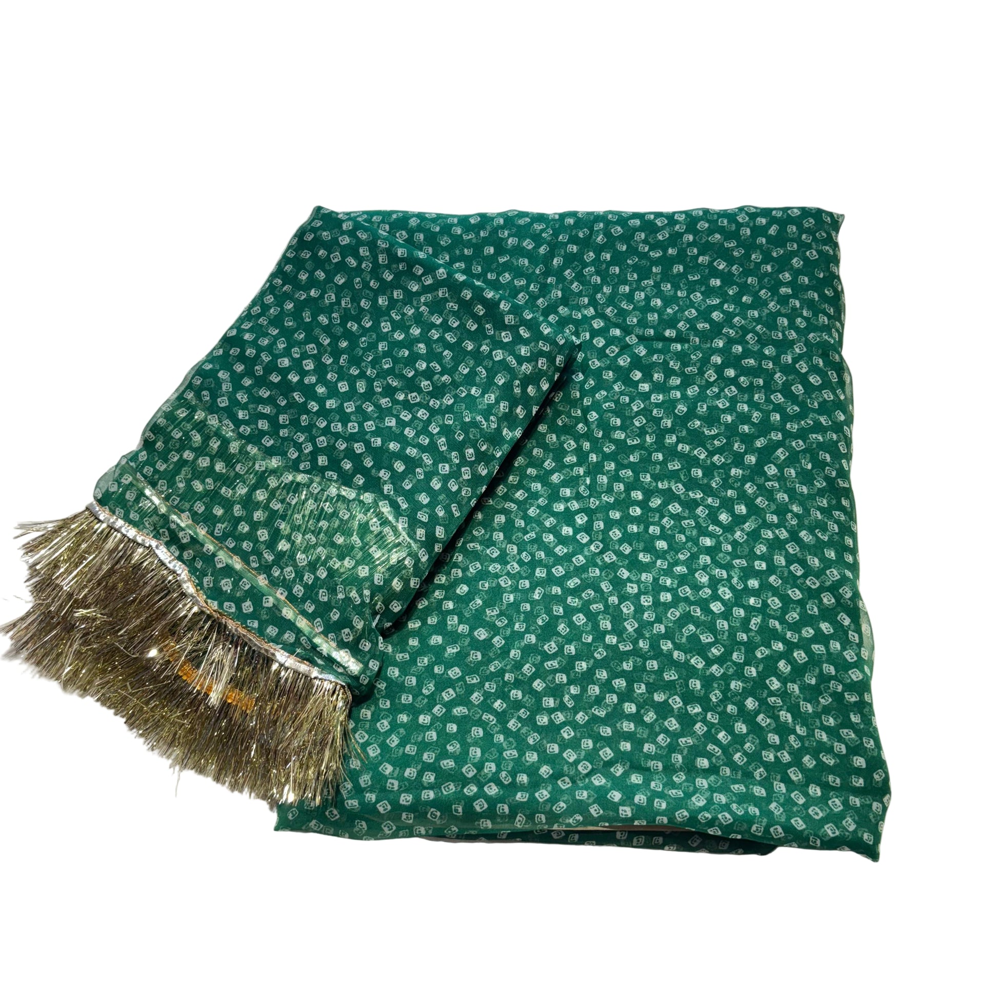 Green fabric with white patterns and gold fringe on a light gray background