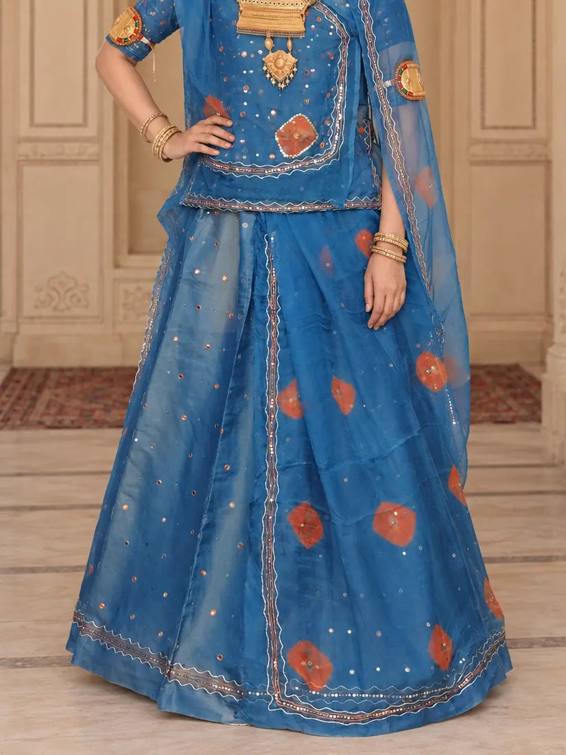 Lehenga close-up showing orange circles, scattered mukesh dots and the zig-zag mukesh hem border