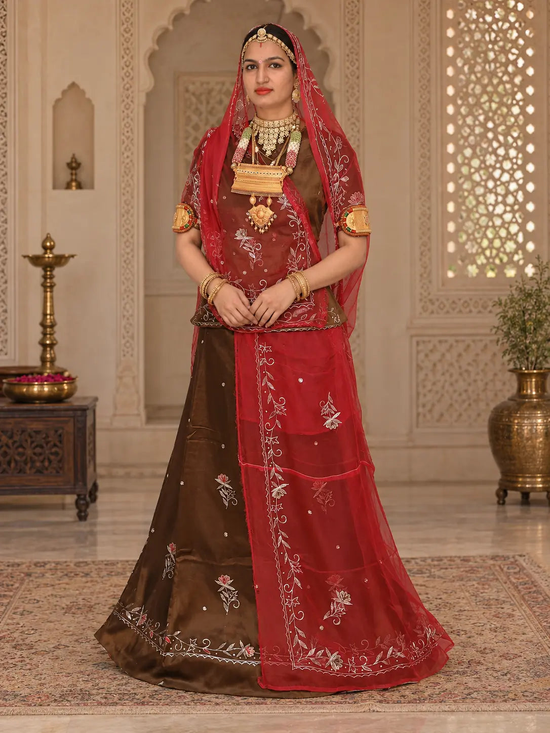 Brown jaam cotton Rajputi suit with a red tora odhni, zari flower buttis and a leaf bel on the lehenga hem, full front view