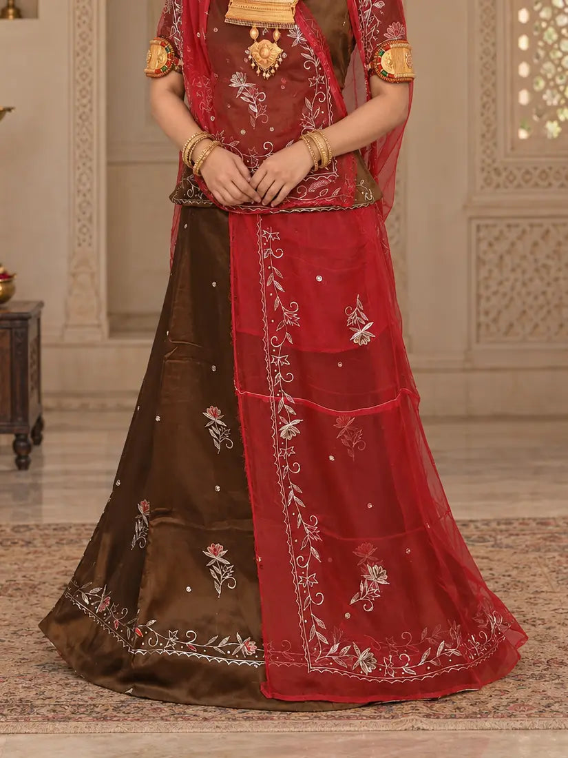 Lehenga close-up with pink and silver zari flower buttis on brown cotton and the red odhni falling down the front