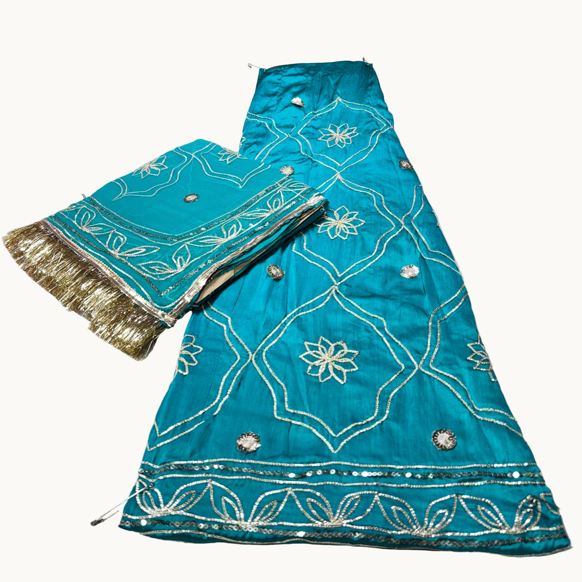 Turquoise fabric with gold and silver embroidery on a white surface