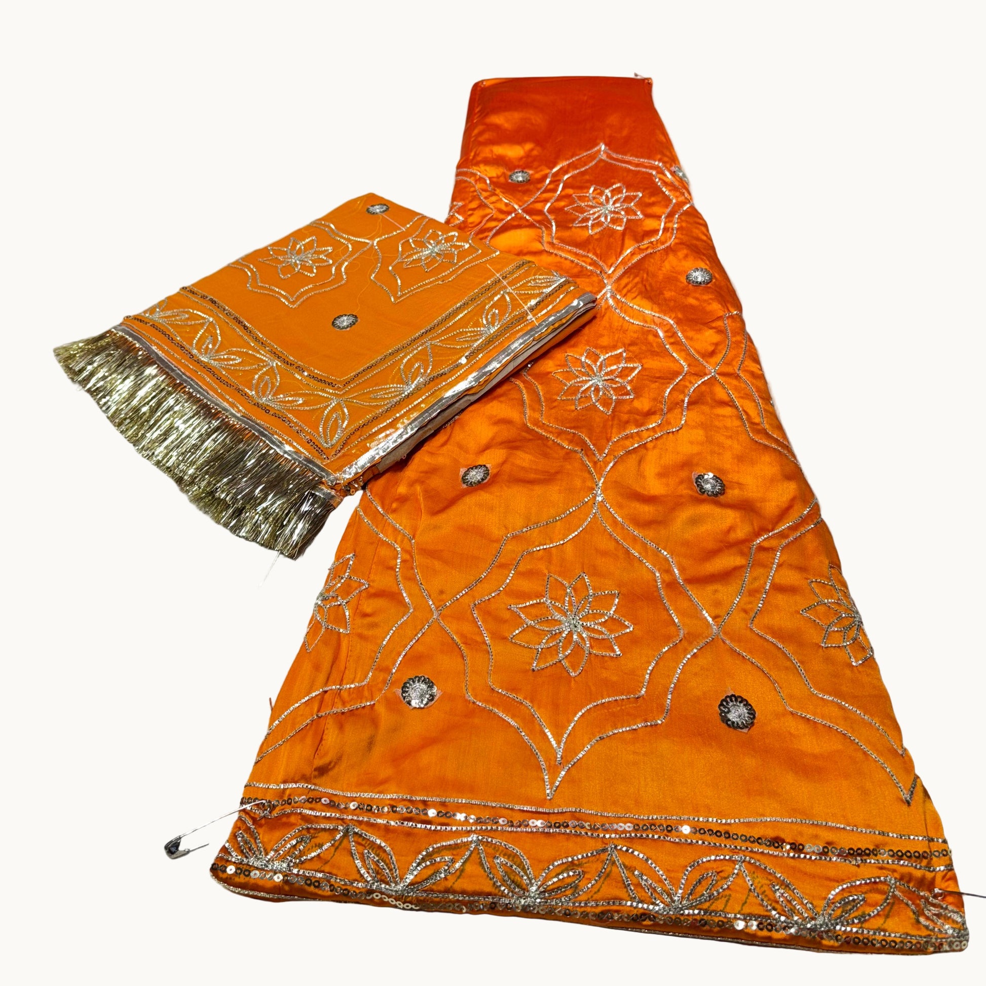 Orange fabric with silver embroidery and gold trim on a white background