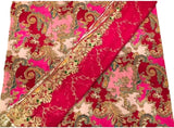 A folded textile with a rich magenta pink and light pink background, decorated with an intricate gold paisley and floral pattern, and a matching metallic gold border.