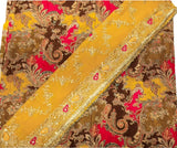 A close-up of a patterned fabric with a mustard yellow border and a brown, gold, and red paisley design.