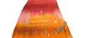 A folded orange and pink gradient fabric, likely a saree or dupatta, featuring small embroidered floral motifs and a decorative border, laid out on a light-colored surface.