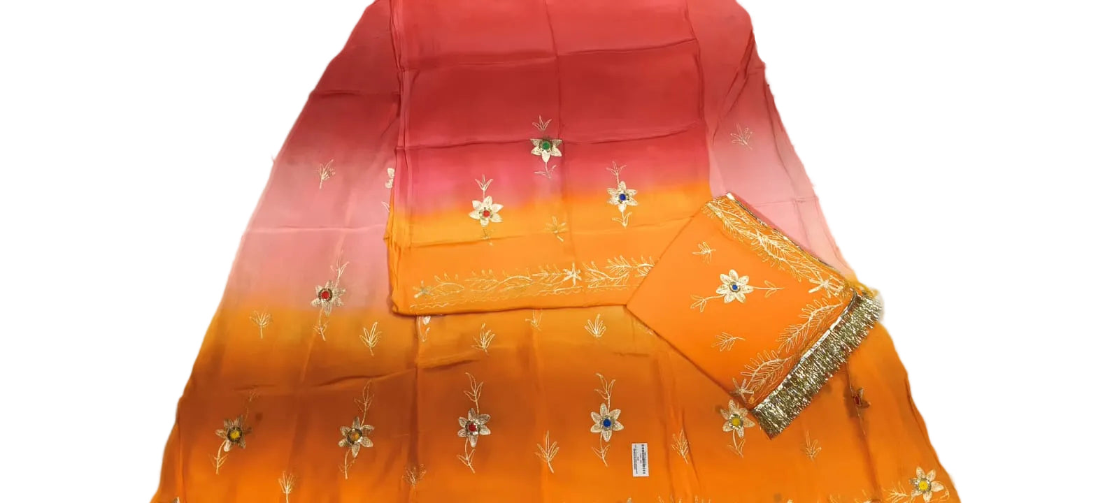 A folded orange and pink gradient fabric, likely a saree or dupatta, featuring small embroidered floral motifs and a decorative border, laid out on a light-colored surface.