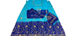 A blue and turquoise gradient ethnic dress with gold embroidery, laid flat on a white fabric surface alongside matching accessories.
