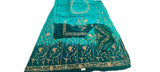 A teal blue and green embroidered ethnic suit set laid flat on a white fabric surface, featuring a kurta, dupatta, and matching embroidered fabric pieces with gold and silver embellishments.