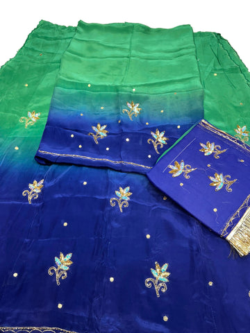 Royal blue Rajputi poshak fabric shading into sea green, with blue sequin flower butti and a folded royal blue odhni with golden fringe