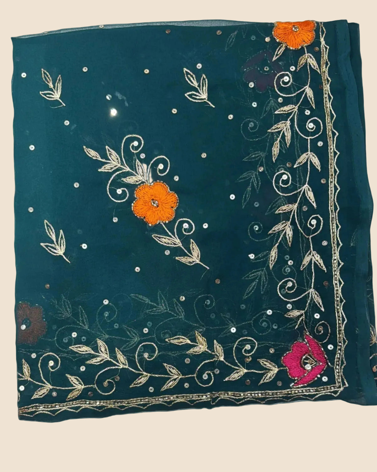 Teal fabric with floral and leaf patterns on a textured surface