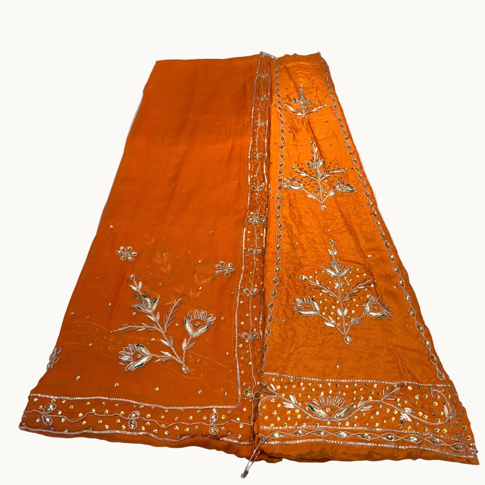 Orange fabric with silver embroidery on a white background