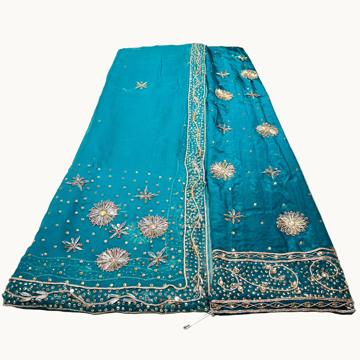 Teal embroidered saree on a white surface