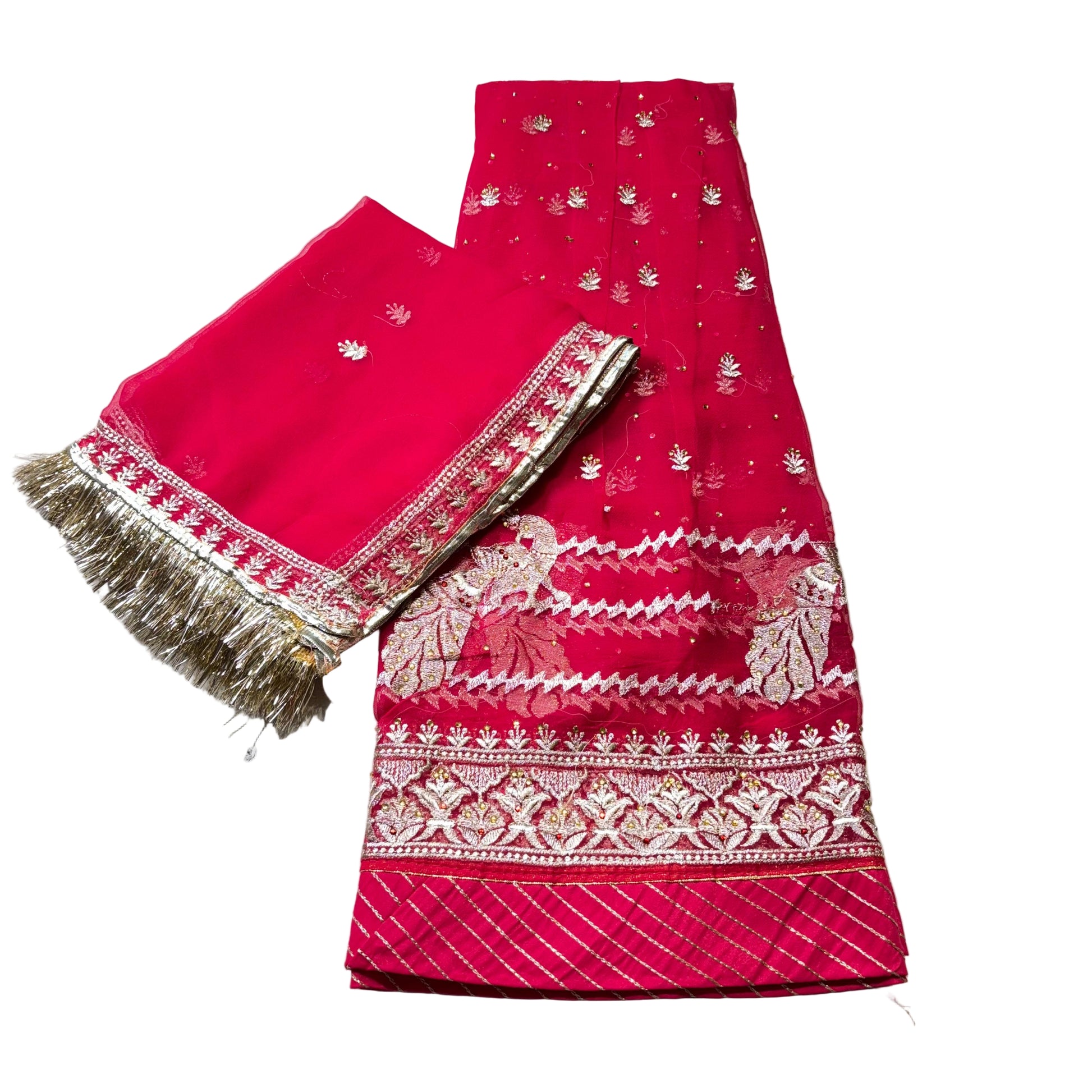 Red fabric with white patterns and fringes on a light gray surface