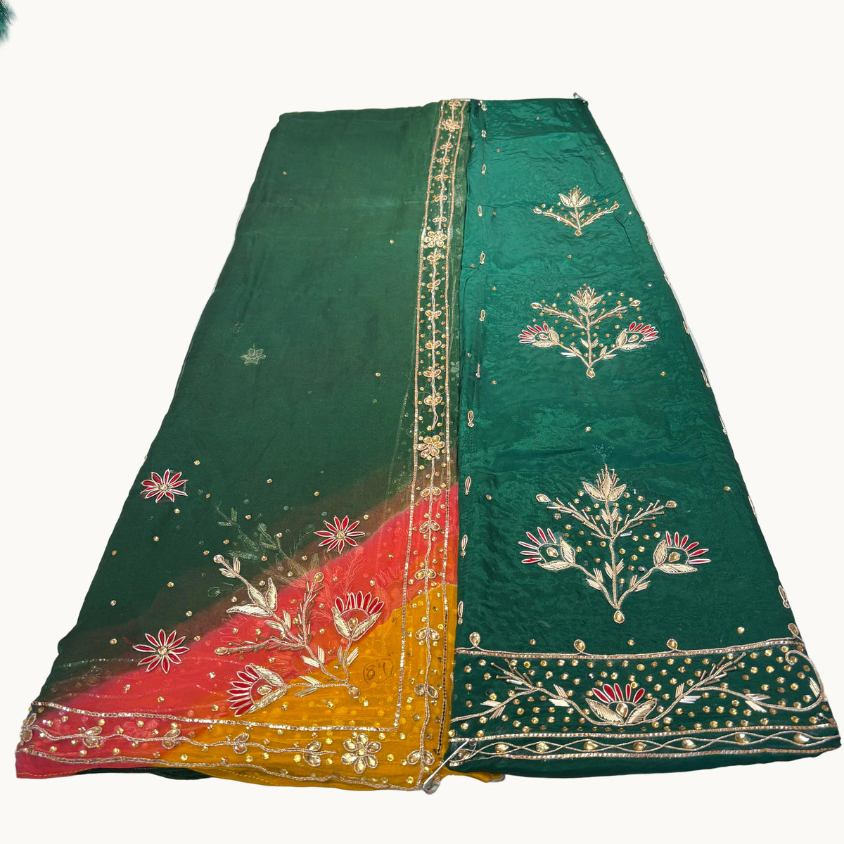 Green embroidered saree with floral patterns on a white background