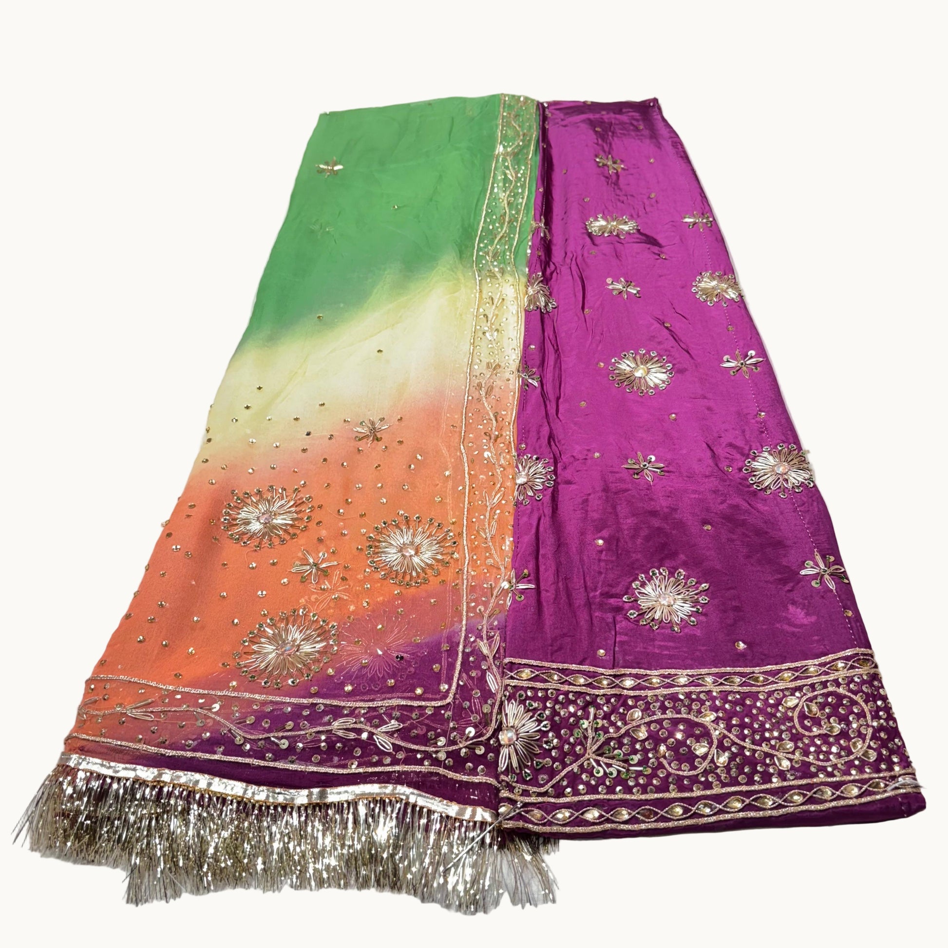 Colorful embroidered fabric with a gradient from green to purple on a white surface