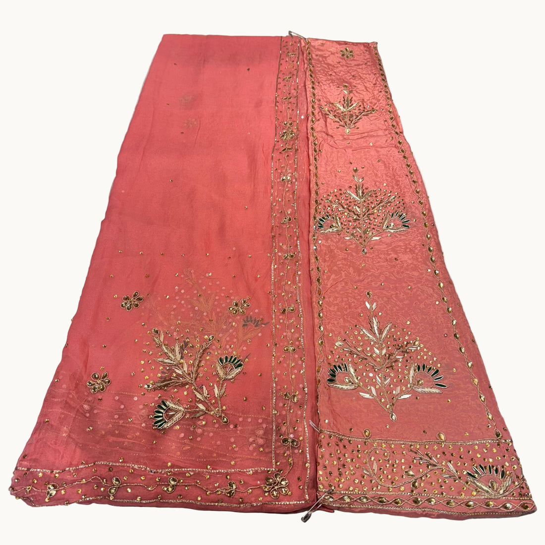 Orange fabric with gold embroidery on a light gray background