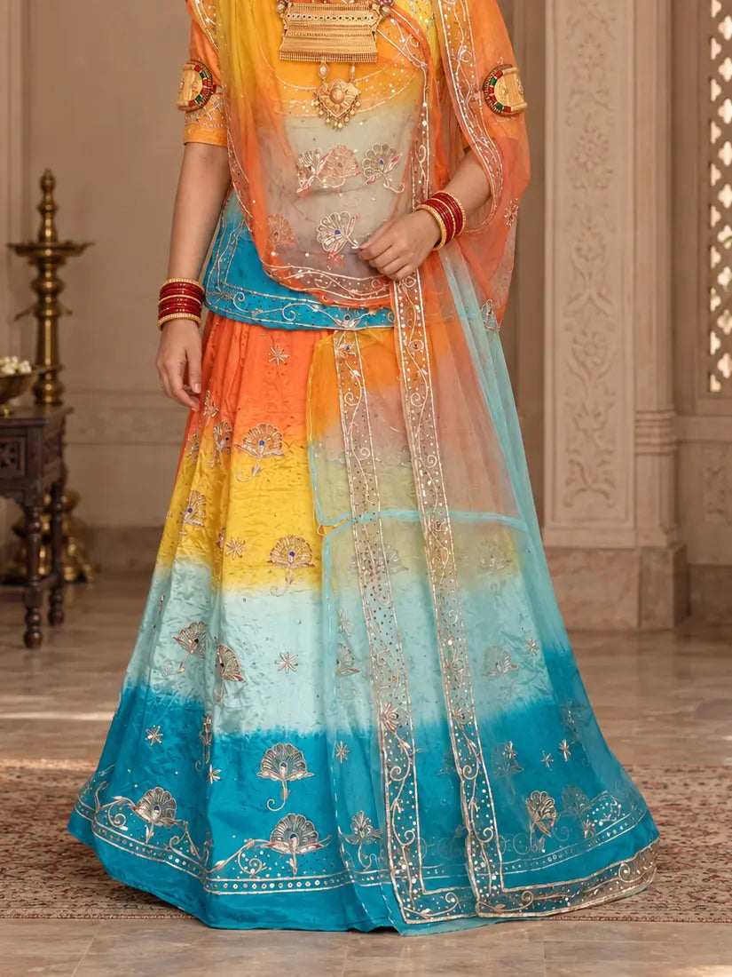 Lehenga close-up showing orange, yellow and firozi bands with zardozi fan buttis