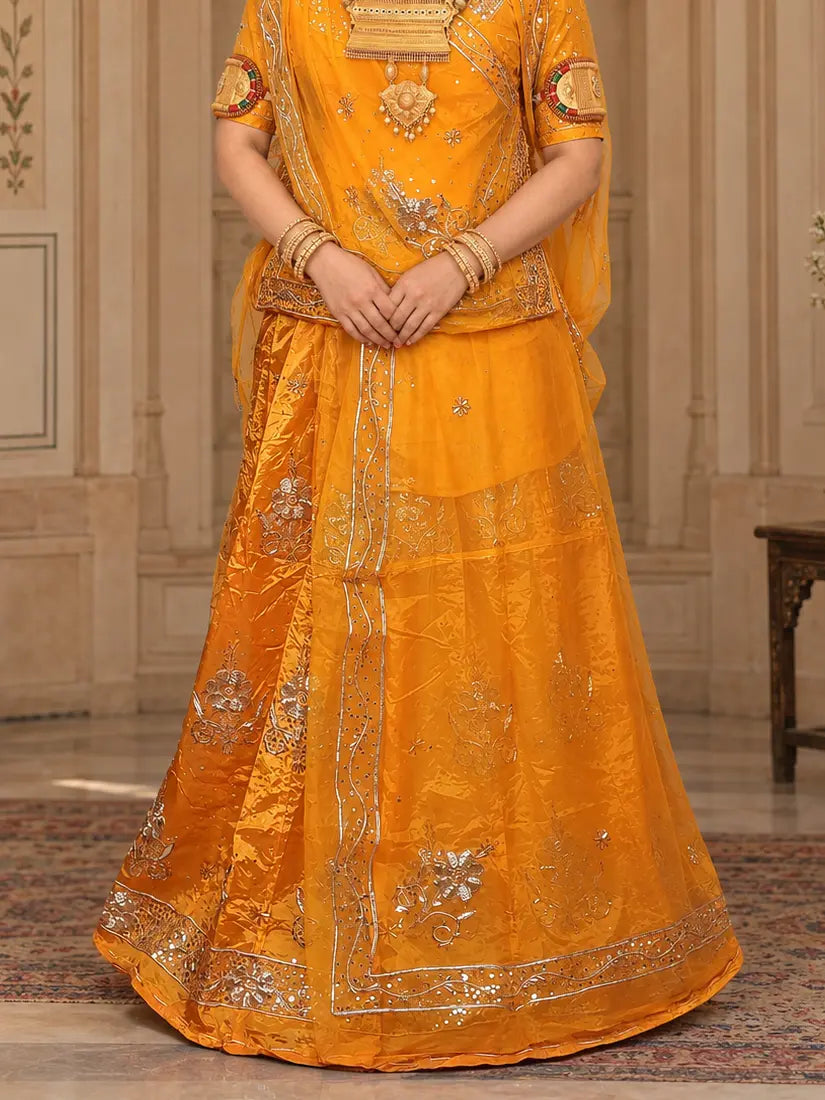 Mustard yellow lehenga close-up with silver zardozi flowers, sequin dots and a zardozi bel hem border