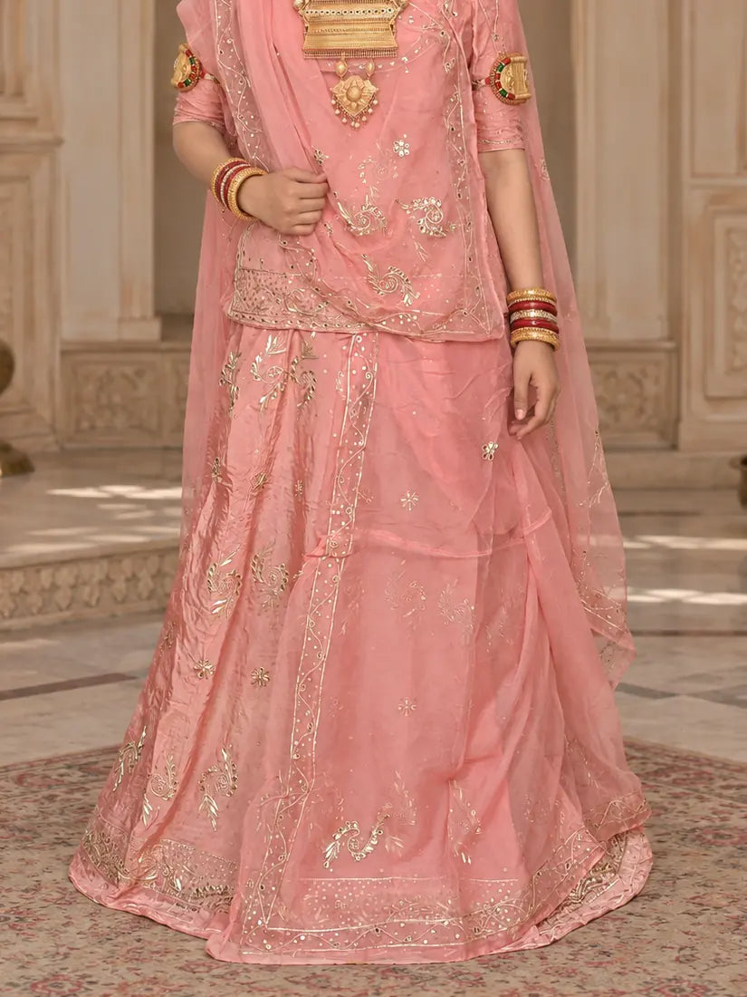 Peach pink lehenga close-up with zardozi leaf buttis, sequin dots and a wide zardozi hem border