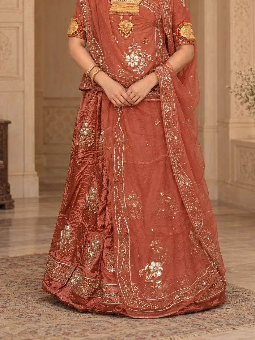 Rust orange lehenga close-up with silver and gold zardozi flower buttis, sequin dots and a zardozi bel hem border