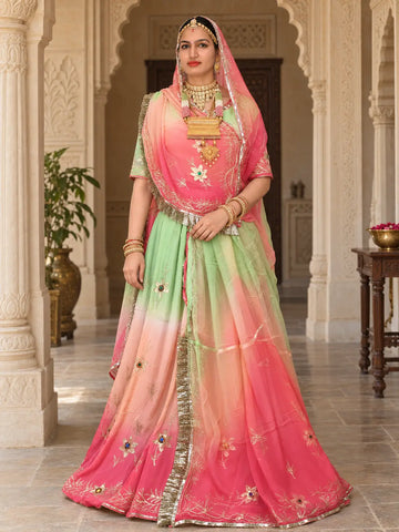 Pure shaded Rajputi poshak, full length, with the lehenga fading from pista green at the waist to pink at the hem, zari flowers with coloured stones, and a fringed odhni falling down the front