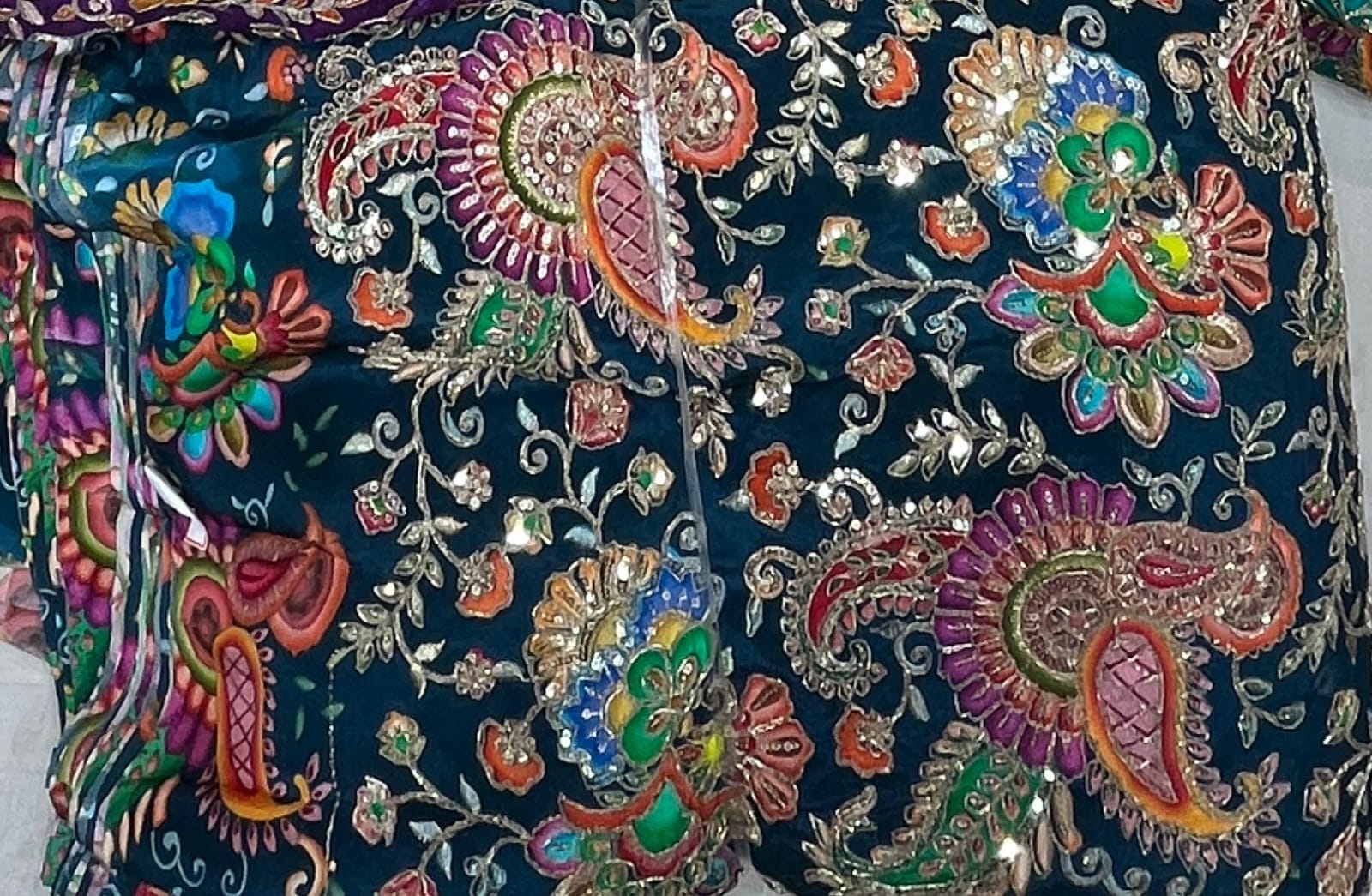 Decorative fabric with colorful paisley patterns on a dark background