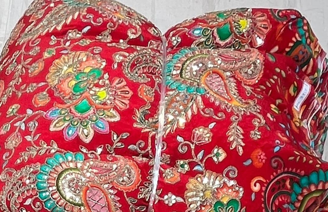 Red fabric with intricate gold and multicolor embroidery