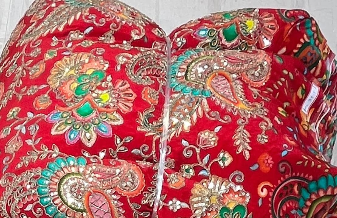Red fabric with intricate gold and multicolor embroidery