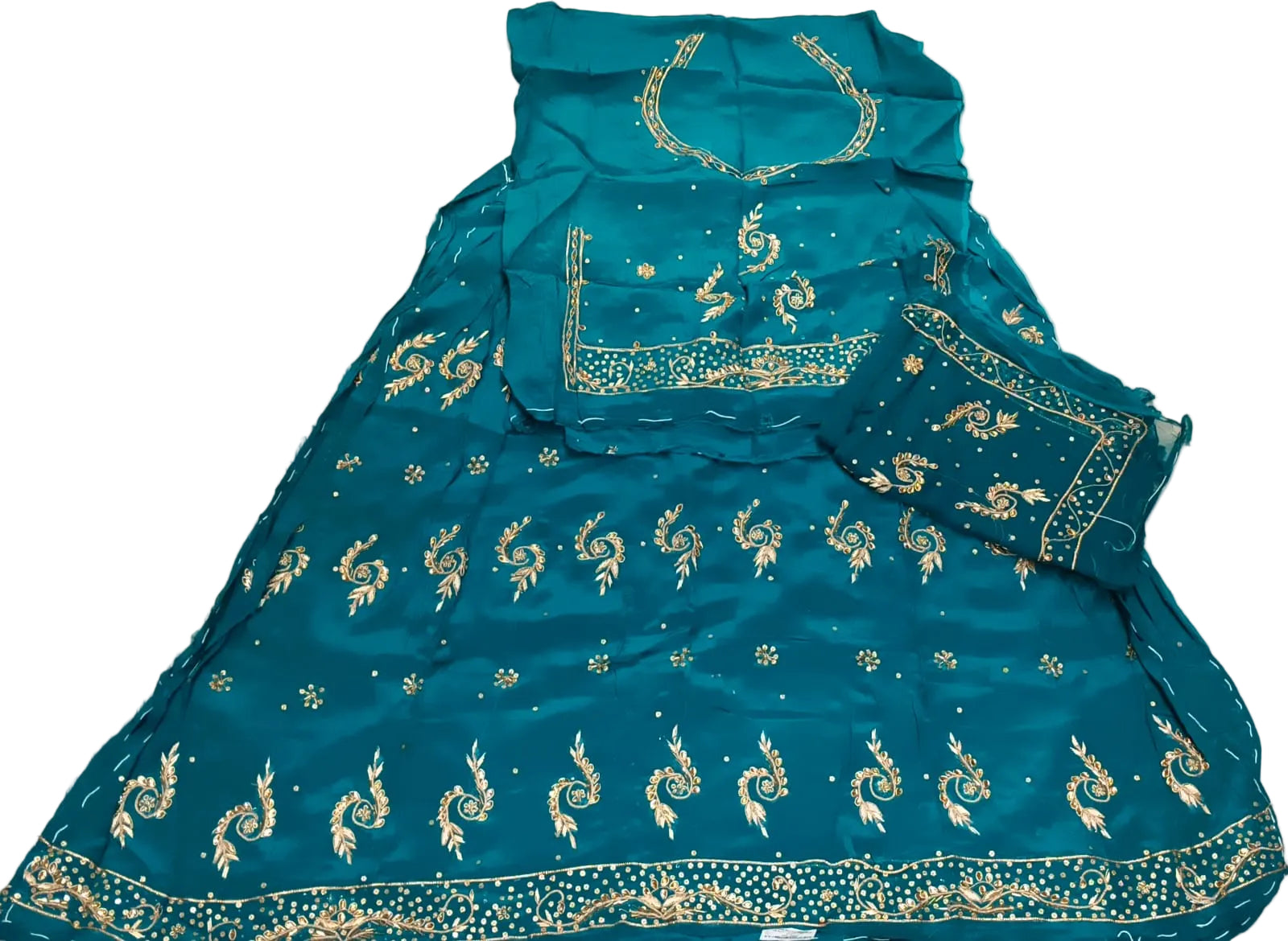 Blue embroidered garment on a white bedspread