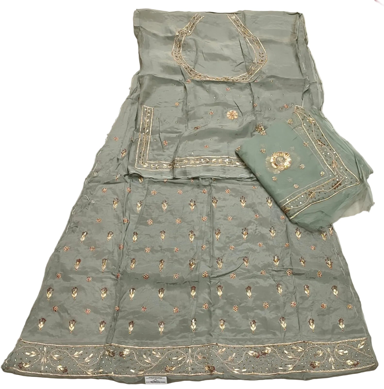Green embroidered traditional outfit on a white bedspread