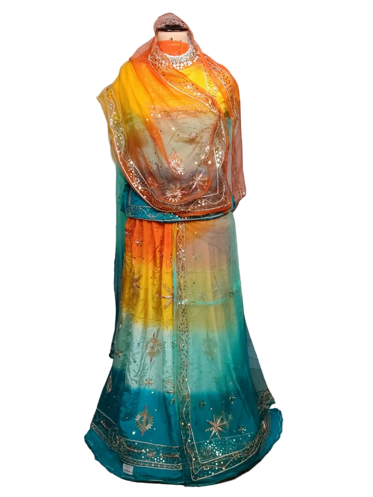 A traditional Indian outfit displayed on a mannequin, featuring a vibrant gradient skirt in yellow, orange, and teal with gold embroidery, a matching teal dupatta, and a yellow-orange blouse.