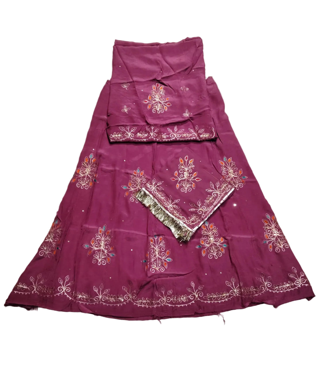 A magenta purple embroidered traditional Indian outfit laid flat on a wrinkled light gray fabric background. The set includes a flared skirt, a matching sleeveless top, and a dupatta with intricate floral embroidery and metallic borders.