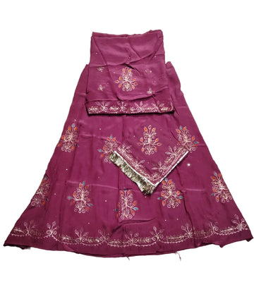 A magenta purple embroidered traditional Indian outfit laid flat on a wrinkled light gray fabric background. The set includes a flared skirt, a matching sleeveless top, and a dupatta with intricate floral embroidery and metallic borders.