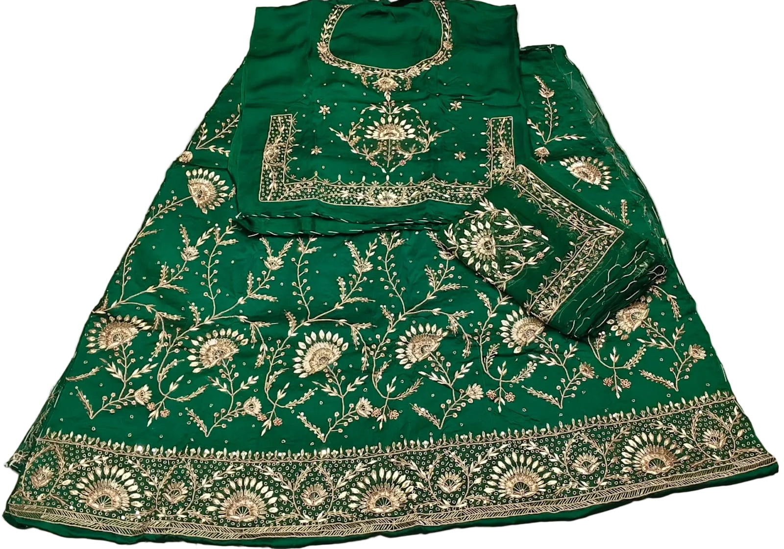 Green embroidered traditional outfit on a white surface