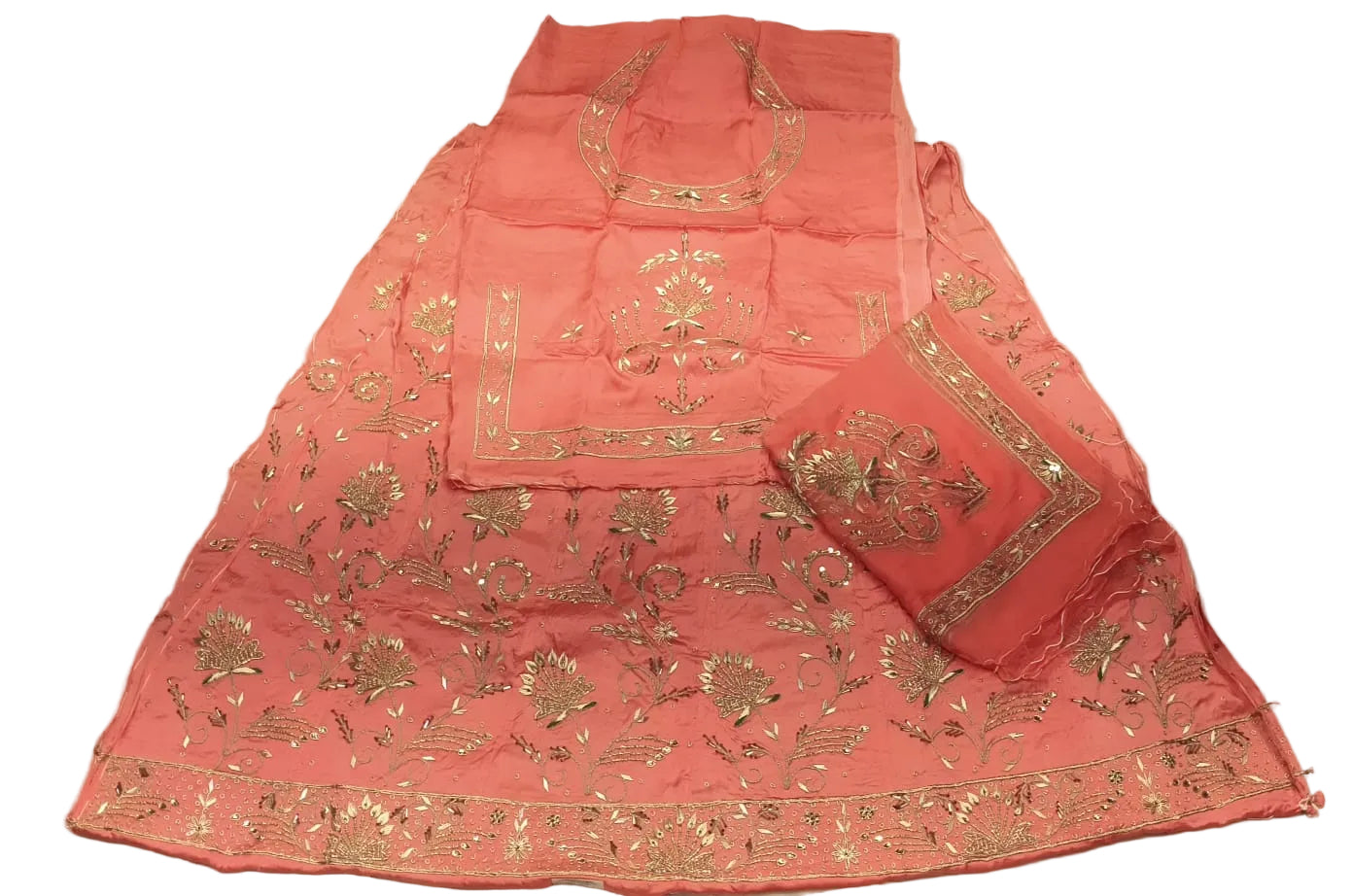 Pink embroidered garment on a white bedspread