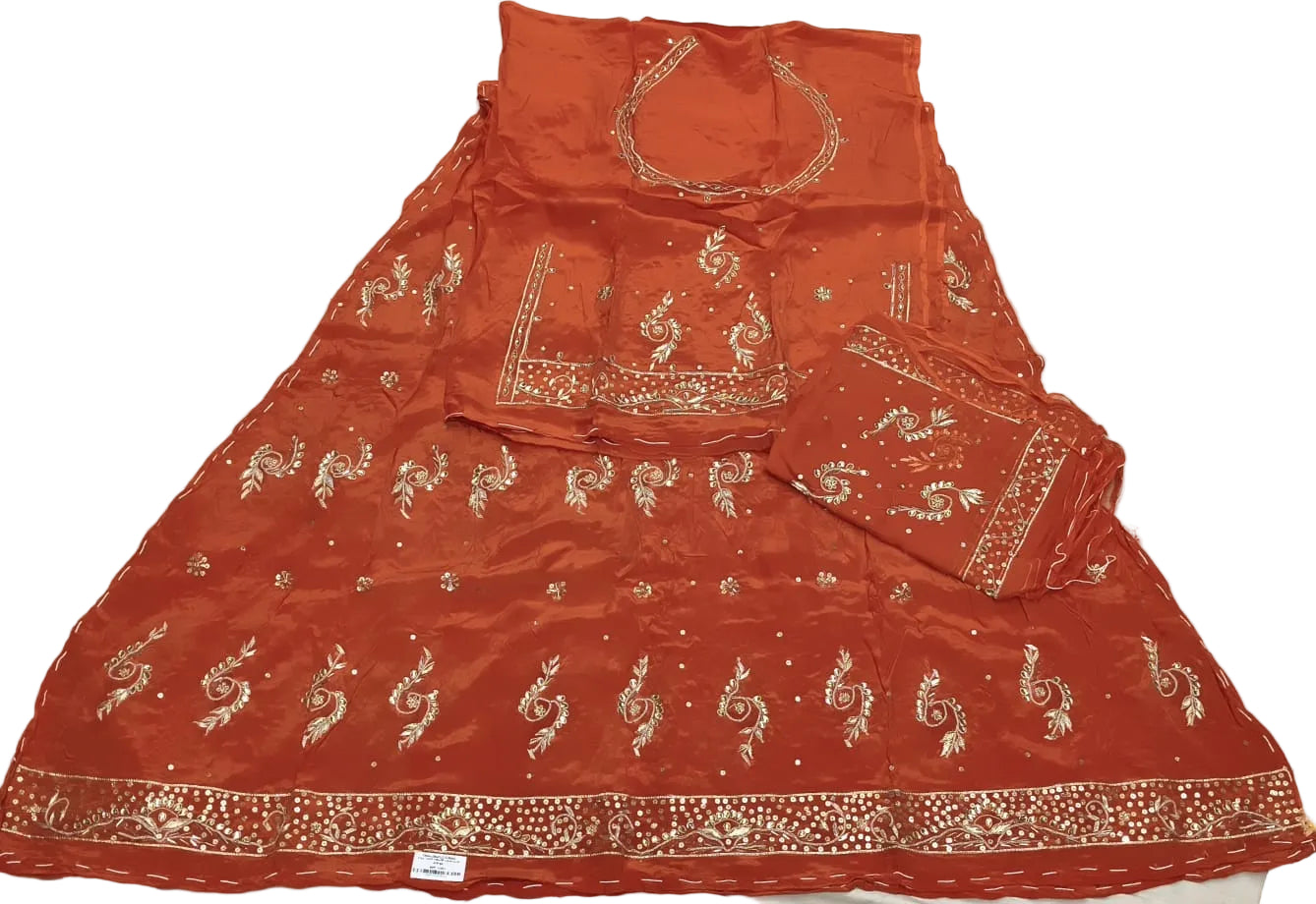 Red embroidered traditional outfit on a white fabric background