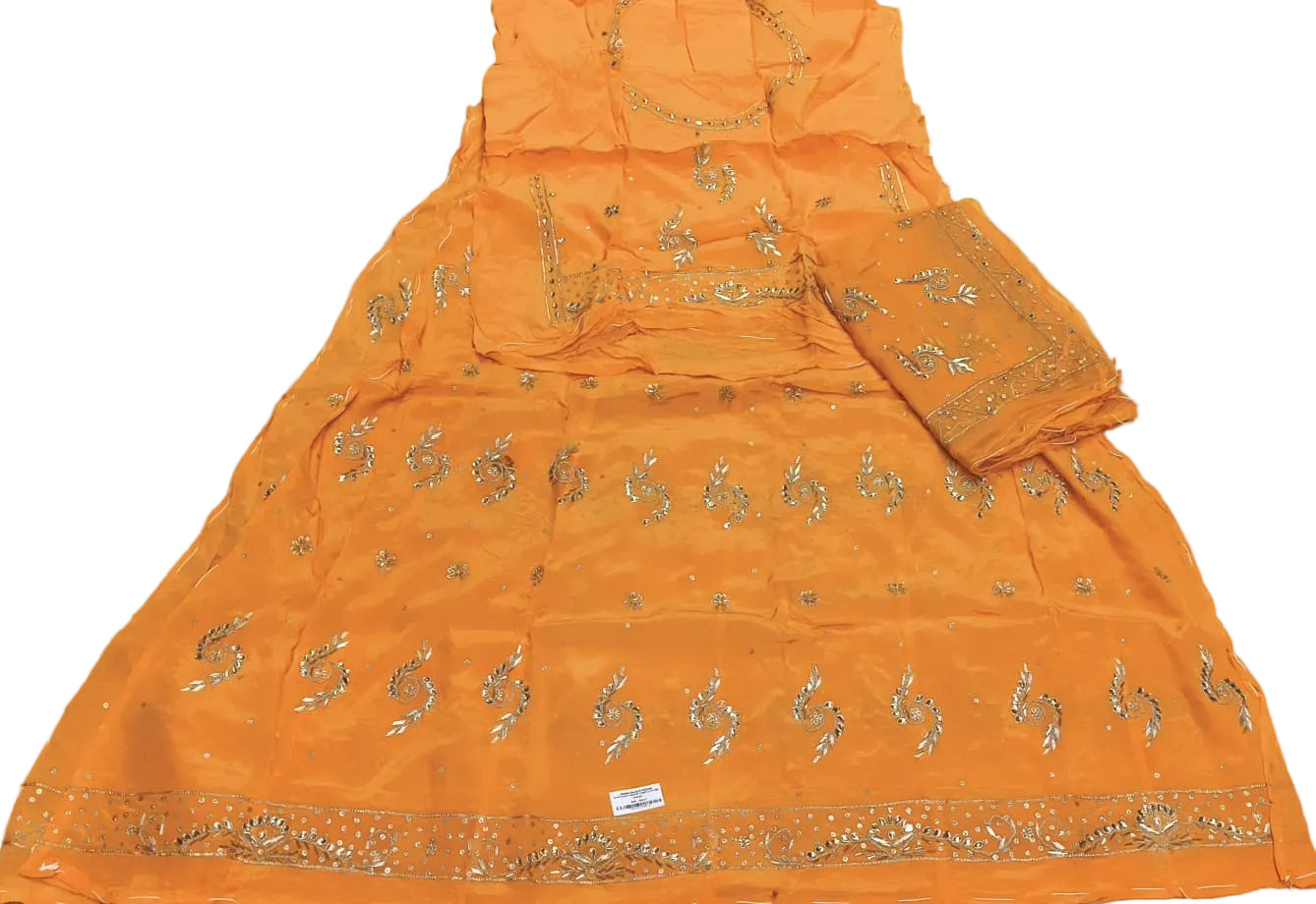 Orange traditional outfit with gold embroidery on a white fabric background