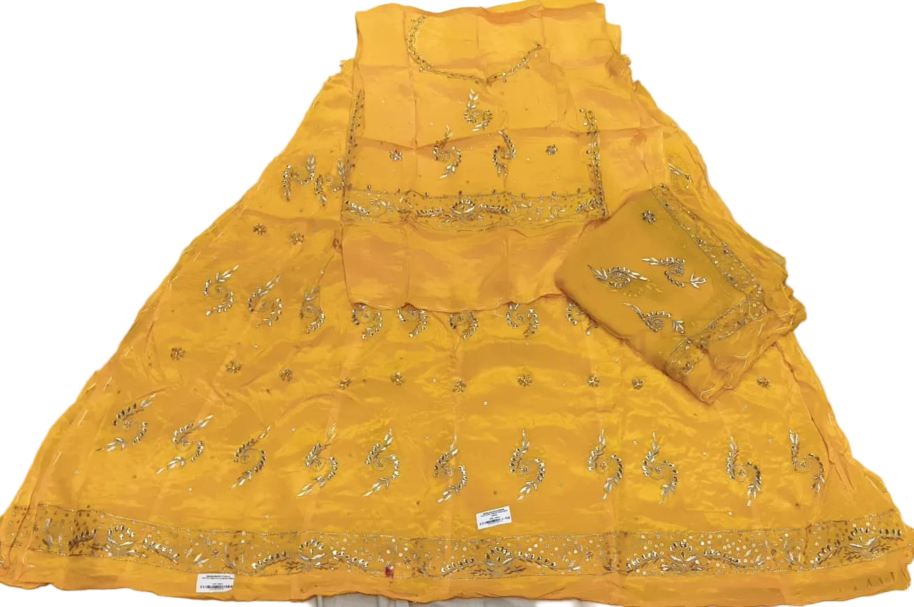Yellow embroidered fabric with gold patterns on a light gray background