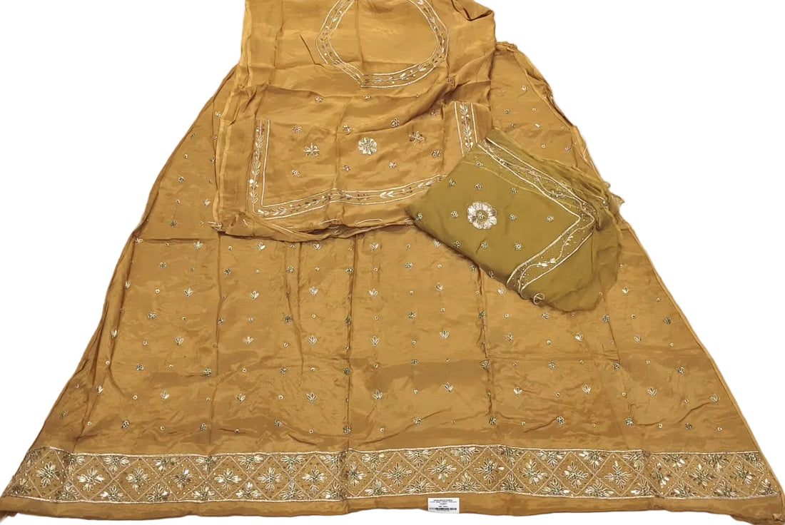 Green embroidered traditional outfit on a white bedspread