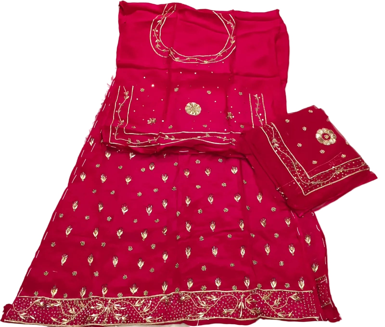 Red traditional outfit with gold embroidery on a white bedspread