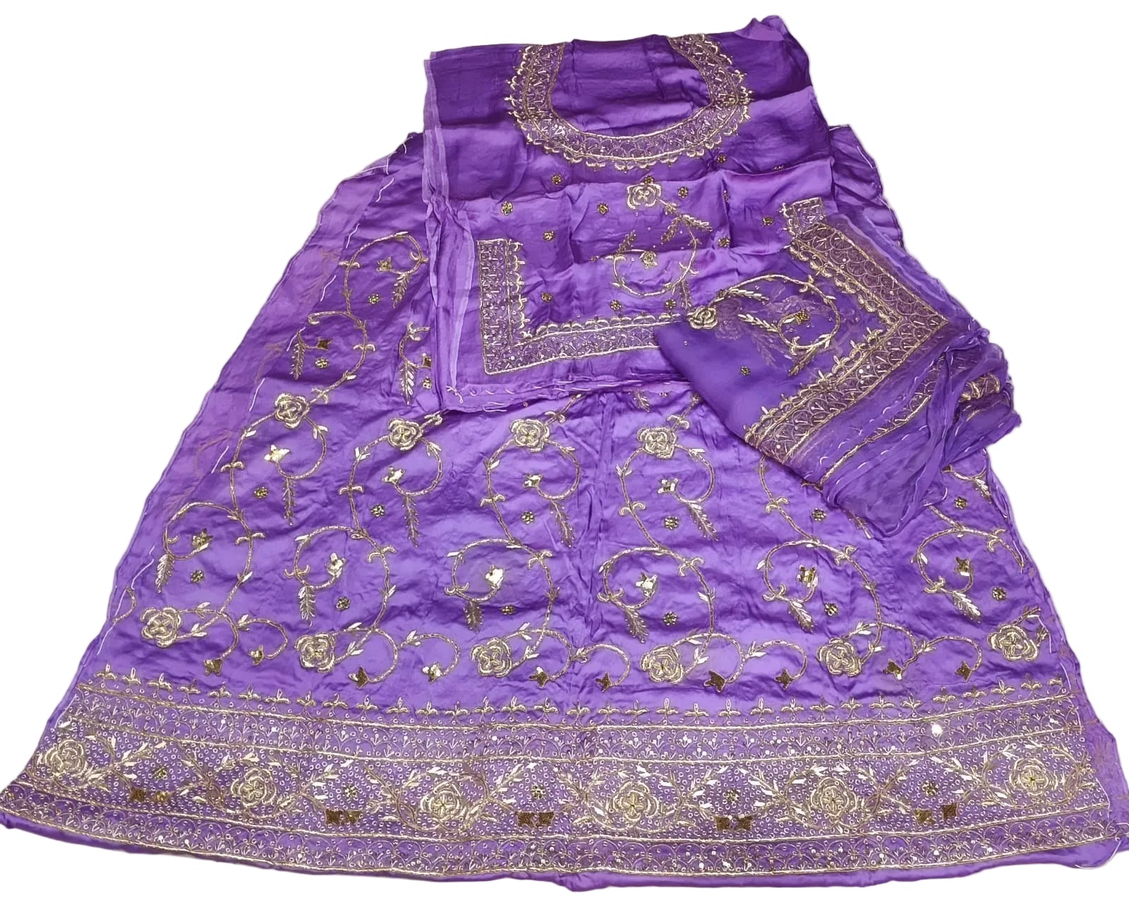 Purple embroidered fabric with gold patterns on a white background