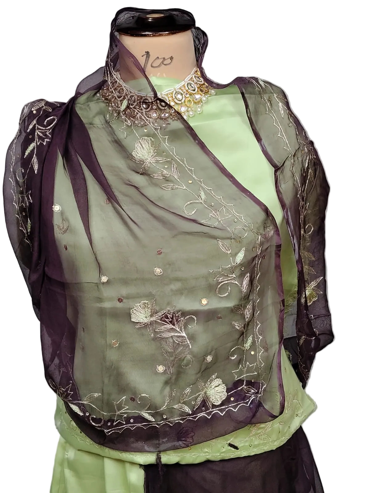 A dark purple sheer organza dupatta with floral embroidery and gold sequins, draped over a light green satin kurta on a mannequin torso.