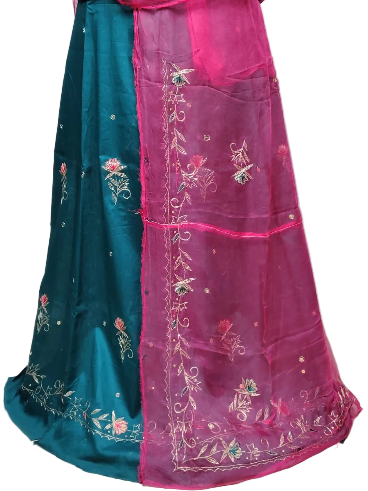 A traditional Indian skirt or lehenga in two main colors: a deep teal blue on one side and a vibrant magenta pink on the other, both adorned with intricate floral and vine embroidery.