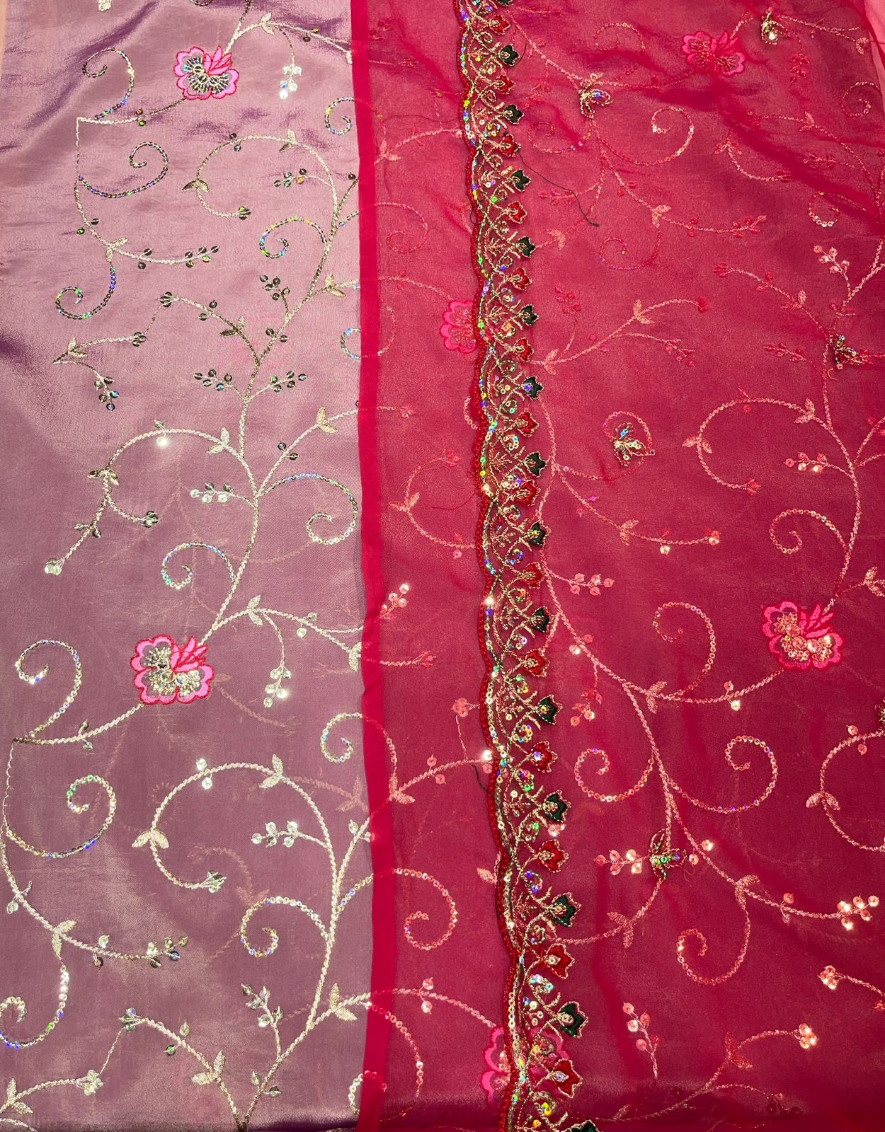 Decorative fabric with floral patterns and embroidery on a pink and red background