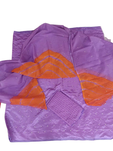 Purple and orange fabric set laid flat on a light tiled floor, featuring a purple base with small silver embellishments, a matching purple square piece, and two orange draped fabric sections.