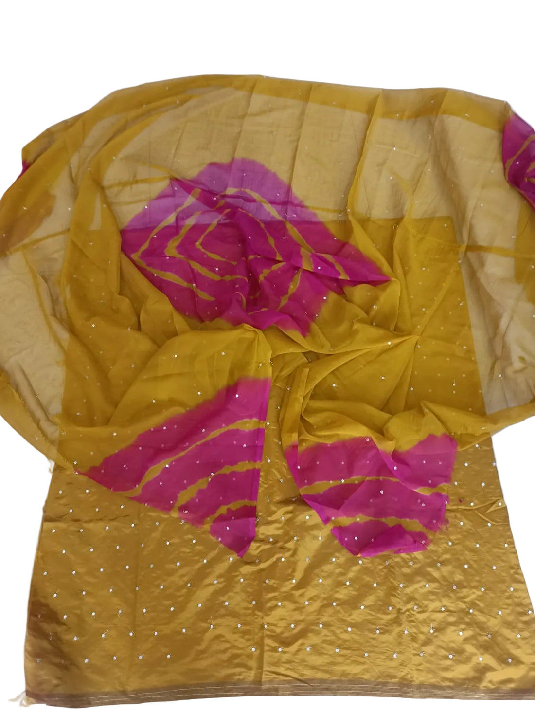 A mustard yellow and magenta pink saree fabric set with small silver sequins, laid out on a white floor.