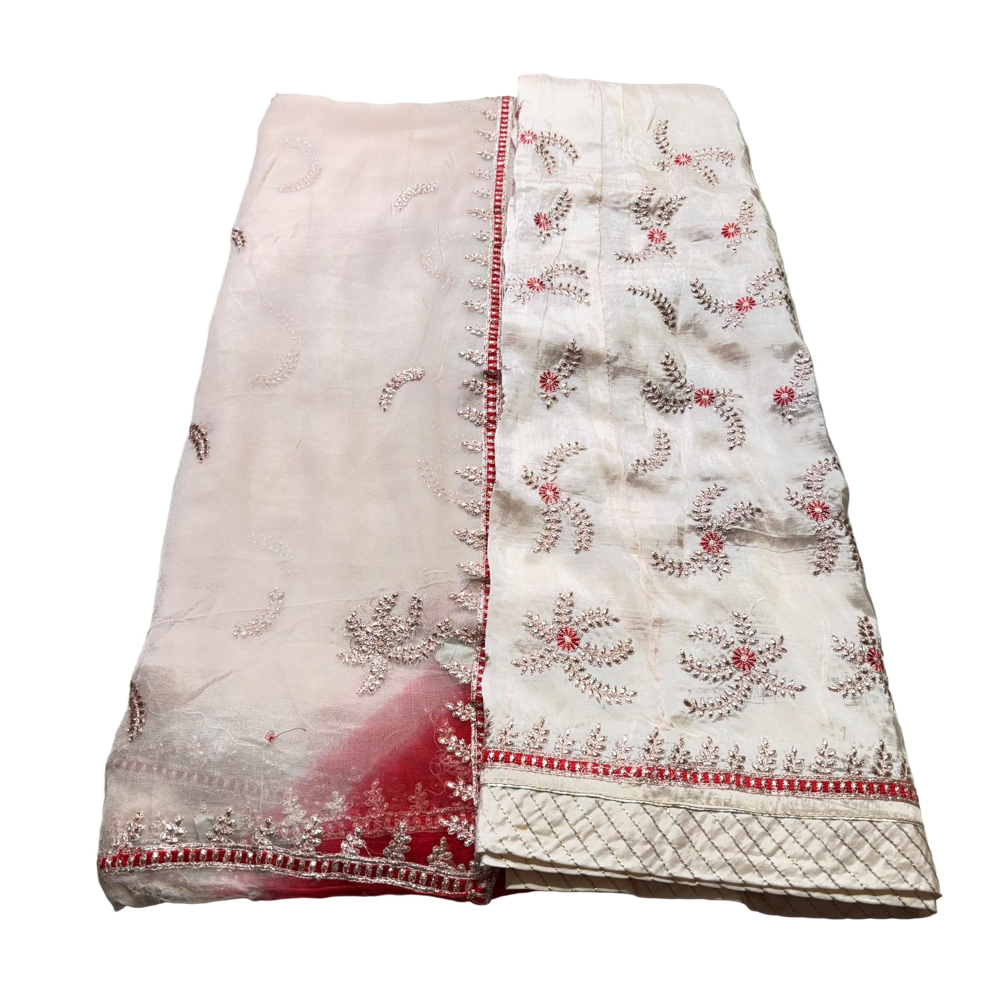 Embroidered fabric with red and white patterns on a light gray background