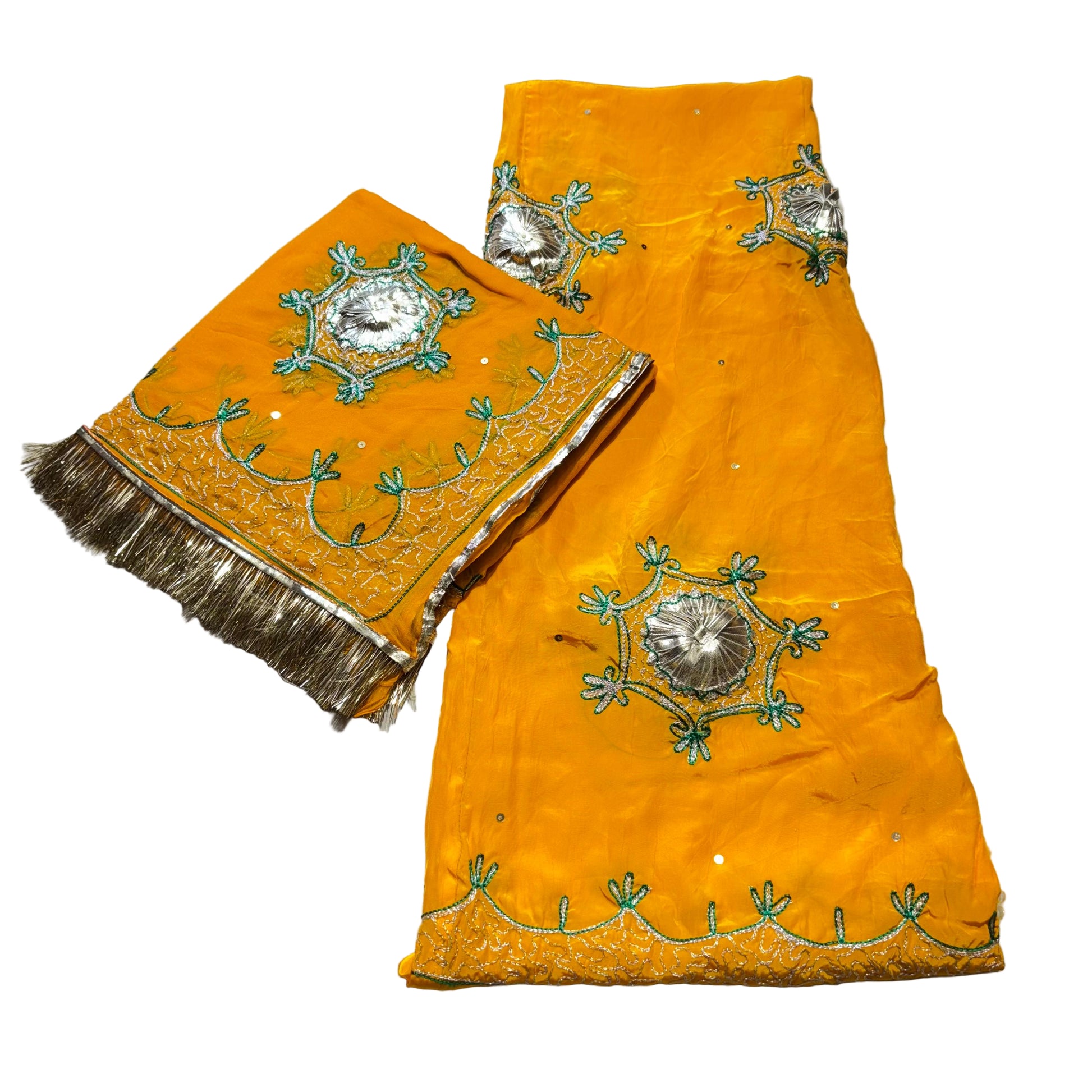 Orange fabric with intricate silver and green embroidery on a light gray background