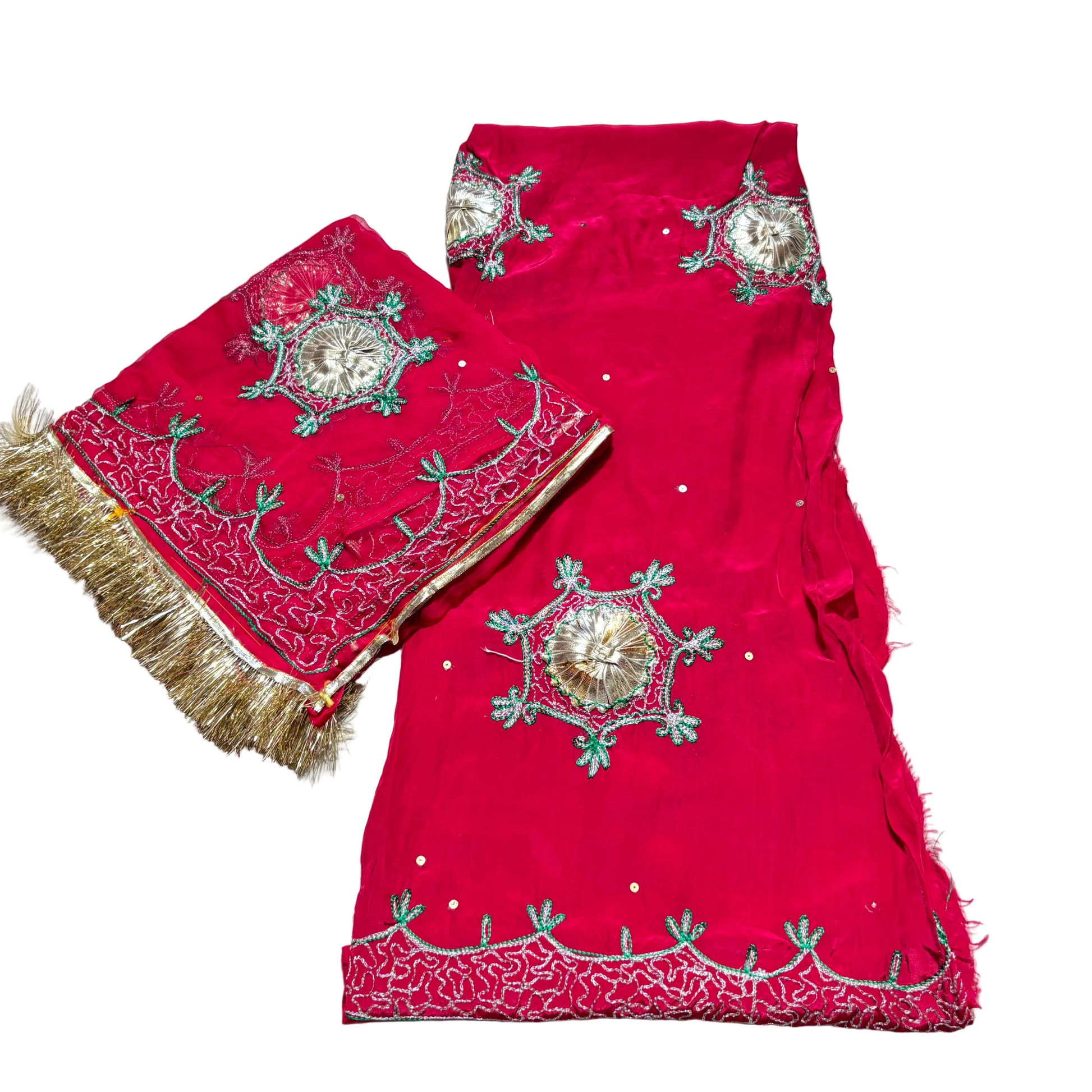 Red embroidered fabric with gold and green patterns on a light gray background