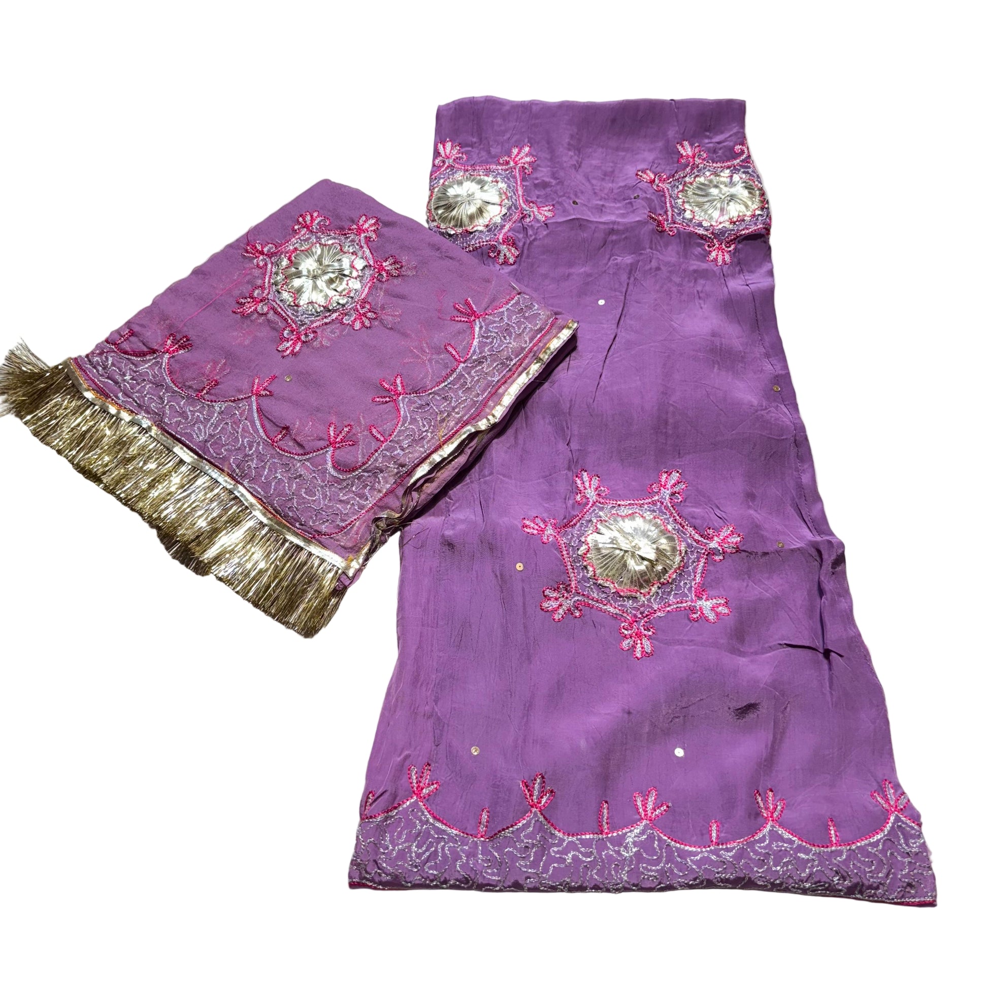 Purple embroidered fabric with gold trim on a gray surface